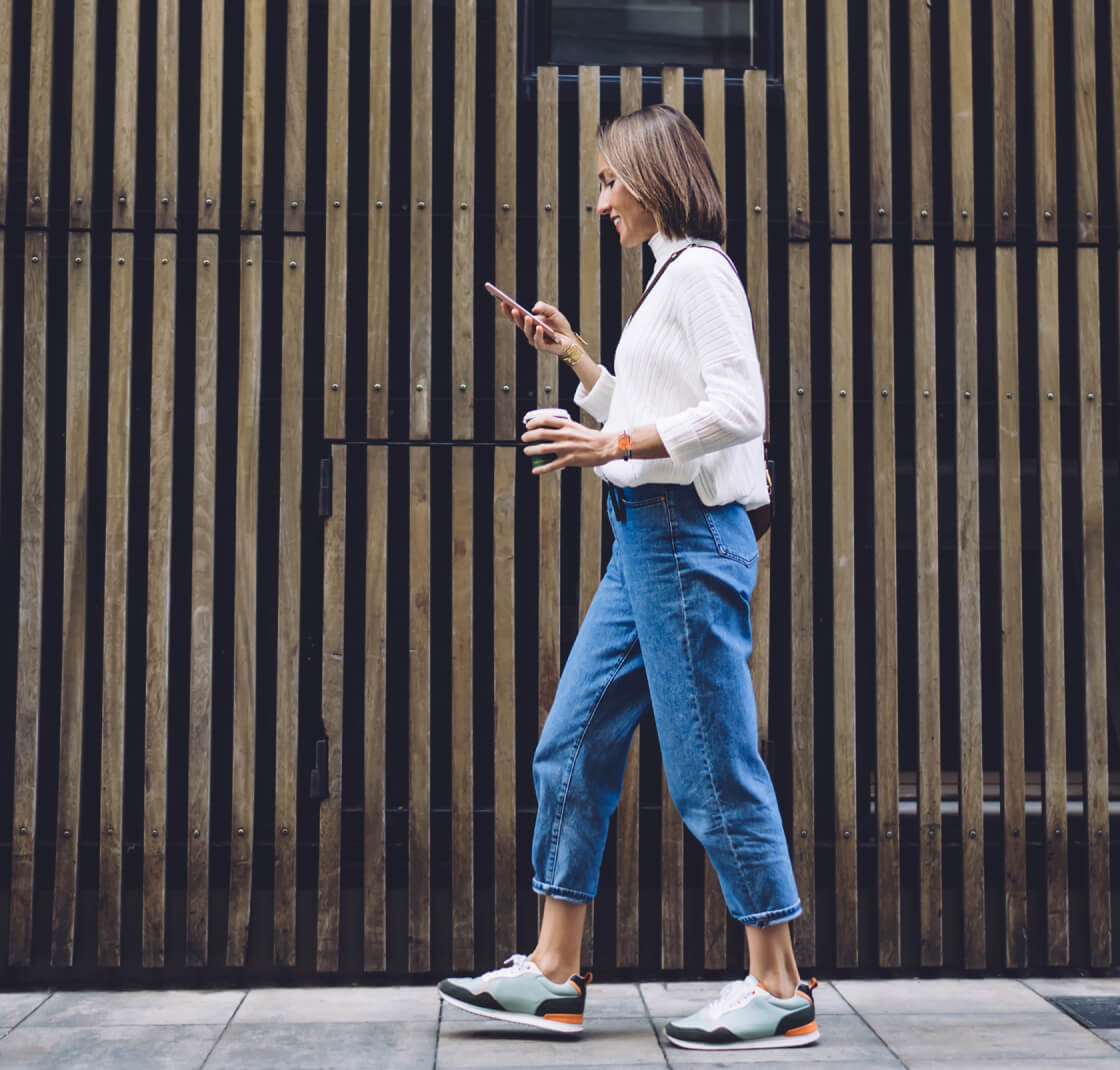 woman walking and looking at phone